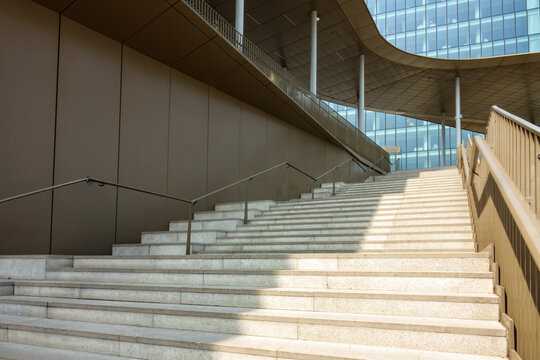 Modern Empty Stone Staircase Leading Up to Curved Glass Office Building, Contemporary Urban Architecture. Urban Design Concept