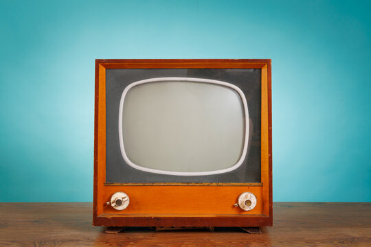 Vintage Retro Television Set on Wooden Table against Blue Background. Nostalgic Analog TV. Retro TV Concept