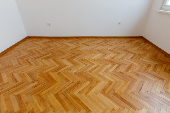 Empty Modern Room with Classic Polished Herringbone Patterned Wood Parquet Flooring. Renovation Interior Design Concept