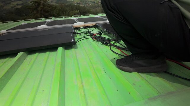 technician plugging solar panel cables on green roof in colombia