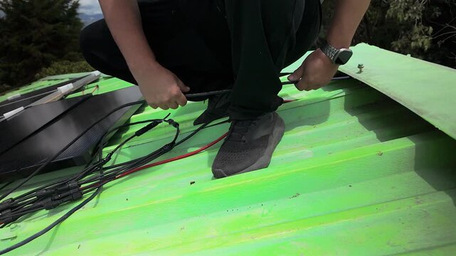 worker wiring solar panels on green roof in colombia
