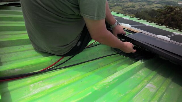person installing solar panel on green roof in colombia