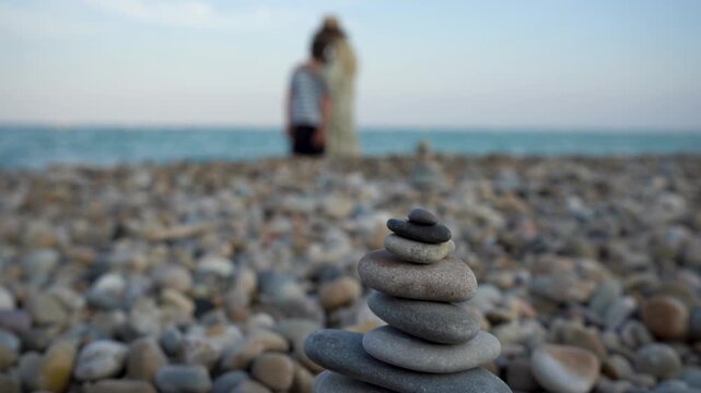 A mother and son are standing on the seashore