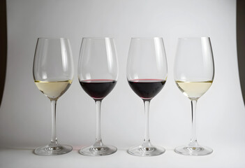 Fototapeta premium Four wine glasses with red and white wine, tasting and comparison concept, isolated on a clean white background