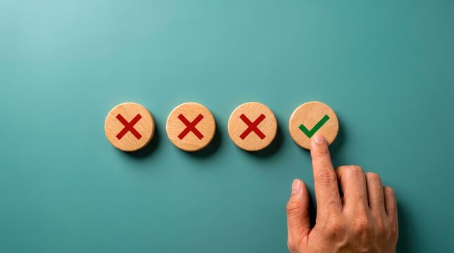 Hand selecting a green checkmark symbol on a wooden circle with three red crosses on a teal background.