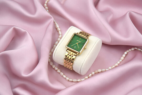 Closeup Burker minimal fashion wristwatch for women on pink background.