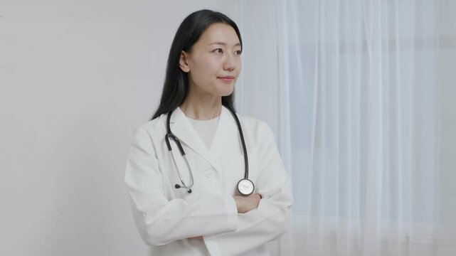 Young Japanese female doctor arms crossed smiling in front of white background