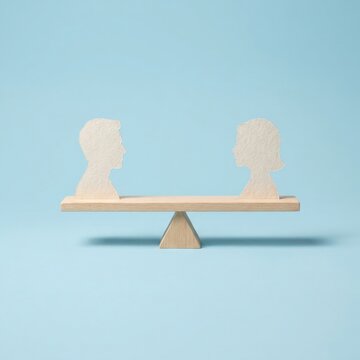 Concept of gender equality and social parity with paper silhouettes on a balanced wooden seesaw.