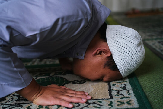 Close-up of the head position during prostration in prayer. Islamic worship. A movement within the prayer. A Muslim man performing prayer.