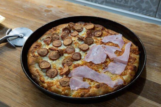 Homemade white pizza with sausage and cooked ham