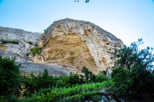 A rock against the backdrop of a blue sky on a clear, sunny day. Nature, landscape, world tourism.