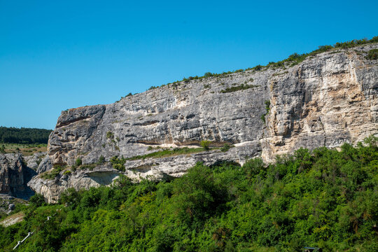 A rock against the backdrop of a blue sky on a clear, sunny day. Nature, landscape, world tourism.