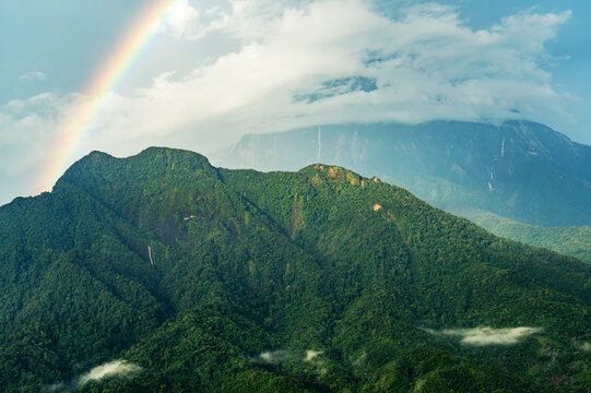 Rainbow over Crocker range Mt Nungkok and Mt Kinabalu in Sabah Borneo