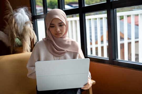 Woman using laptop by the window