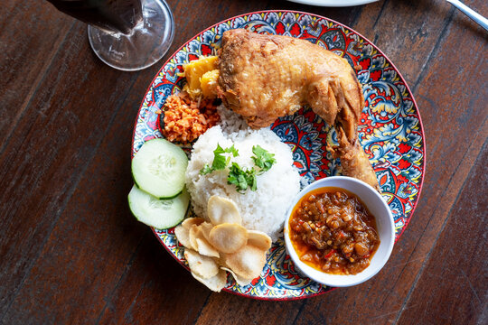 High angle view of white rice and fried chicken with sambal and tuhau