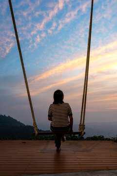 Rear view of a woman on a swing at Bukit Kokol Hills Menggatal Kota Kinabalu Sabah