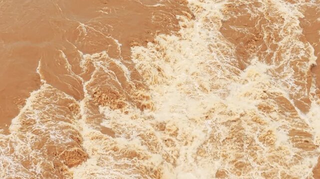Static macro shot capturing turbulent fluid dynamics and violent churning of muddy waters at Hukou Waterfall, highlighting raw natural power, chaotic currents, and earthy brown tones.