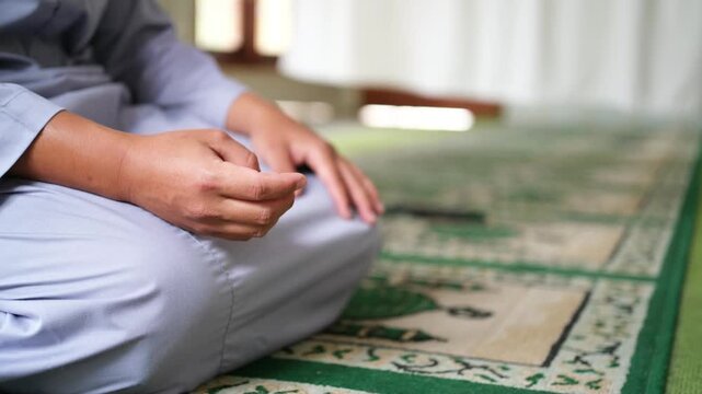A close-up of a person reciting dhikr with their hands, counting on their fingers. A symbol of spiritual practice and devotion. Islam. A Muslim. 
