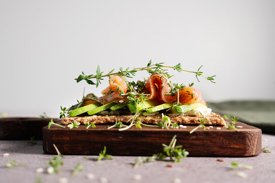 Healthy Scandinavian multi-grain crispbread breakfast with salmon and avocado.