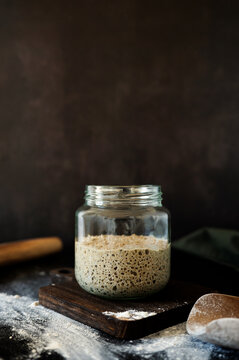 Fermented rye sourdough starter rising with visible yeast bubbles.