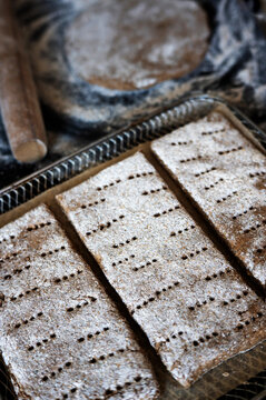 Raw rectangular rye flatbread dough with docker holes.