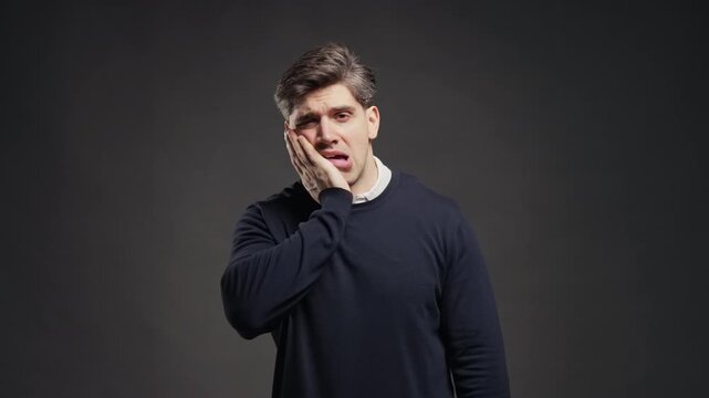 Young Man Touching Cheek With Painful Expression, Reacting To Sudden Toothache, Male Suffering From Dental Pain, Sensitive Teeth, Oral Health Problem And Dentist Visit
