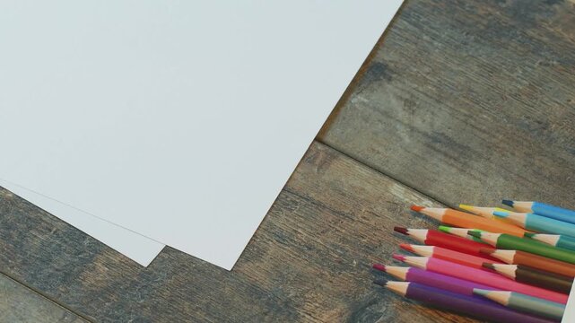 Colored pencils are taken from the table and used on paper