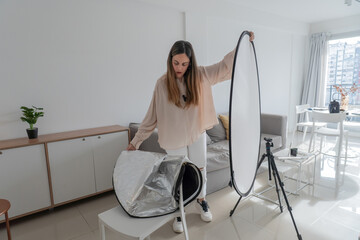 Content Creator Holding Extended White Reflector Near Window © daniromphoto