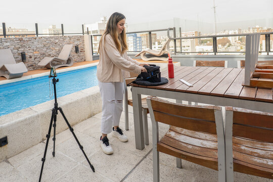 Content Creator Packing Camera Bag On Rooftop Table