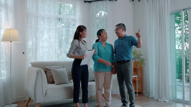 Professional discussing documents and home-related plans with an elderly couple in their living room, representing consultation, retirement planning, home services, and financial decisions.
