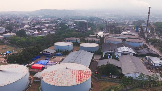 Aerial drone view of an industrial fuel storage terminal in Indonesia, featuring large storage tanks, pipelines, loading facilities, and supporting infrastructure for petroleum products and energy dis