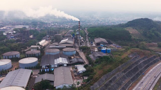 Aerial drone view of an industrial fuel storage terminal in Indonesia, featuring large storage tanks, pipelines, loading facilities, and supporting infrastructure for petroleum products and energy dis