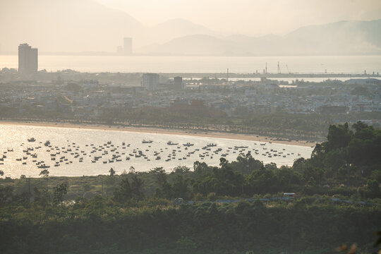 Panoramic view of Da Nang city in Vietnam with coastal area and fishing bay with boats on water, sea bay with many local fishermen fleet boats near shore at sunset surrounding Da Nang city in Vietnam.