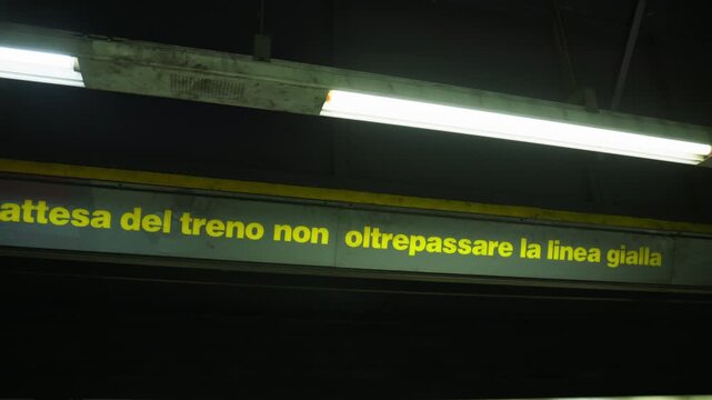 Do not cross the yellow line sign in Italian at a metro station
