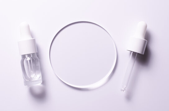 A glass circle on a pink background. A template for placing samples of cosmetics or medical products or food.