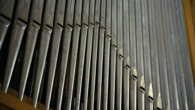 Long metal pipes of an organ playing in an Italian religious cathedral