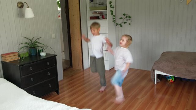 Happy active siblings exercising dancing together. Cute brother and sister jumping, doing fun sports routine. Fighting sedentary lifestyle in kids. Children physical health, energy wellness concept.