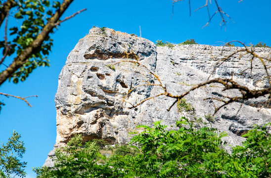 A rock against the backdrop of a blue sky on a clear, sunny day. Nature, landscape, world tourism.