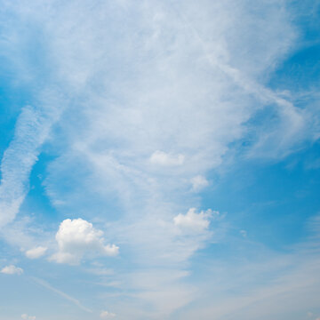 Heavenly Background with Wispy Clouds and Linear Jet Trails