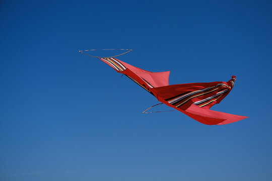 Traditional Balinese red kite flying in a clear blue sky