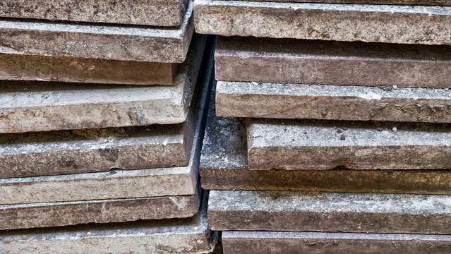Stacked concrete slabs forming a textured background, highlighting the rough surfaces and material layers suitable for architectural or construction related themes