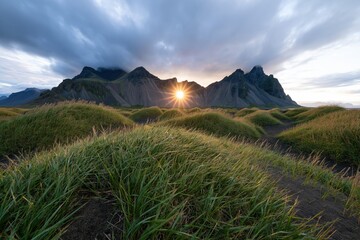Obraz premium The Sunrise Over Rugged Mountain Range Amid Rolling Grasslands At Dawn