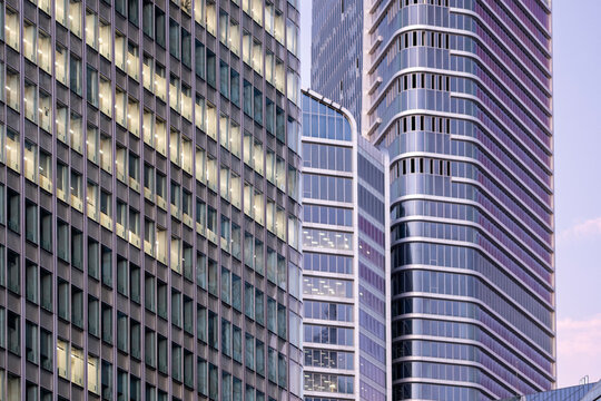 Across La Defense, Paris, France, curved glass office towers and a gridded facade compress the urban skyline, giving the architecture a rhythmic evening pattern.