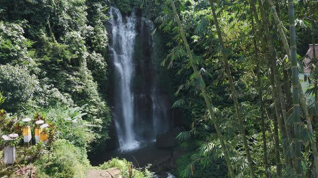 Tropical scenic waterfall with sunlight, jungle forest in Bali. Drone view