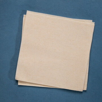 blank cocktail napkin against textures art paper
