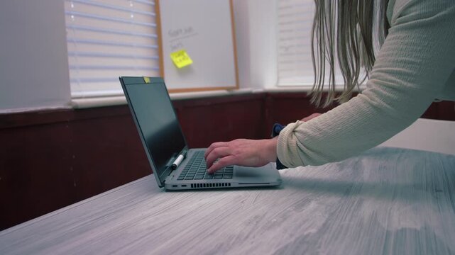 Woman typing on laptop in office