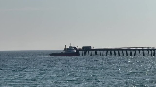 Boat docked at an industrial pier transporting workers to and from the offshore oil platform, Goleta, Santa Barbara County, Southern California