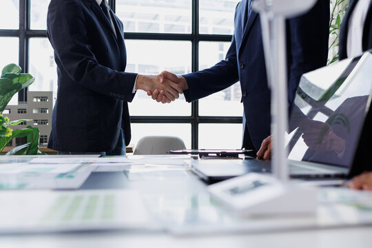 Business partners shaking hands sealing a deal at office meeting, collaborating on corporate partnership for success