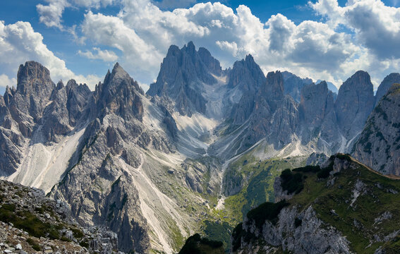 Majestic scenery of rough mountain ridge near grassy hills Tre Cime, Dolomites Italy