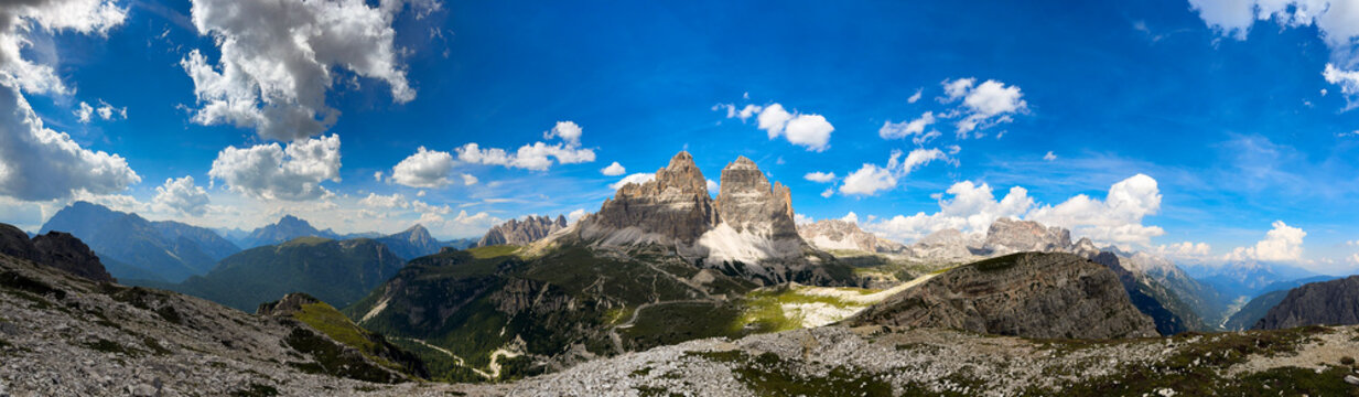 panorama of Tre Cime in the Dolomites, highlighting jagged cliffs and green meadows 